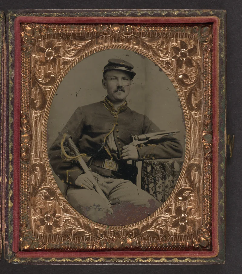 Cased oval portrait in an embossed brass mat: a moustached cavalryman in a forage cap and trimmed jacket, holding a revolver across his chest and a sabre on his knee.
