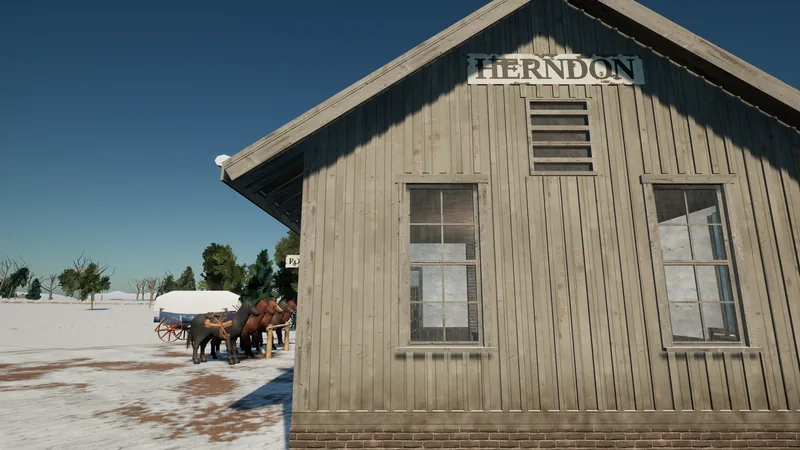 The board-and-batten gable end of a small railway depot with a weathered "HERNDON" sign, two tall windows and a louvre; saddled horses tied at a rail and a covered wagon in the snow to the left.